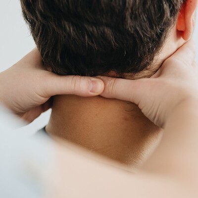Osteopathic practitioner assessing a client's neck